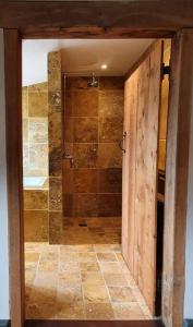 puerta abierta a un baño con ducha en Hound and Human Holiday Cottage - Redgrave, Suffolk en Diss