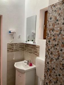 a bathroom with a sink and a toilet and a mirror at Casa Ella in 2 Mai