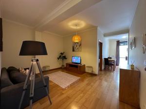 a living room with a television and a tripod at Apartamentos da Carreira in Funchal