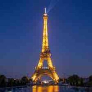 Ein Bild des Eiffelturms leuchtet nachts in der Unterkunft Superbe appartement Disneyland Paris Parking in Lagny