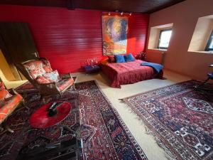 a living room with a bed and a red wall at Große Ferienwohnung Chagall am Duschlberg - Dreiländereck in Neureichenau