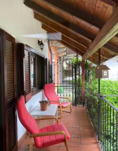 a patio with pink chairs and a table on a balcony at Love Family in Vignone