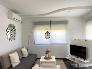 a living room with a couch and a tv at Duplex con piscina individual y vistas al mar en Torrevieja in Torrevieja
