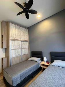 a bedroom with two beds and a ceiling fan at Lucky Home @ Quintet Tanah Rata in Cameron Highlands