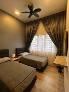 a bedroom with two beds and a ceiling fan at Lucky Home @ Quintet Tanah Rata in Cameron Highlands