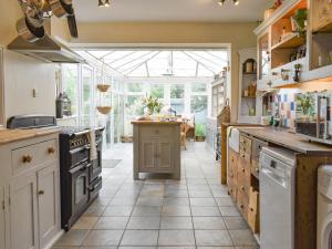 a large kitchen with a large window and an island at Kennelmans in Sopley