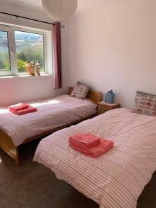 a bedroom with two beds with red towels on them at Two bed flat with stunning views over Fistral Bay! in Newquay