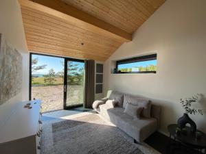 a living room with a couch and large windows at Seaside Rendezvous in Kalana