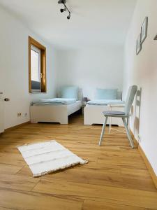 呂德斯海姆的住宿－"Cuvée" Magnum，一间设有两张床、椅子和地毯的房间