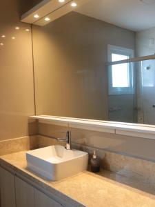 a bathroom with a sink and a mirror at Refúgio Aconchegante em Canela in Canela