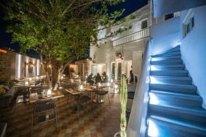 Un escalier mène à un restaurant avec des tables et des chaises. dans l'établissement Fresh Boutique Hotel, à Mykonos