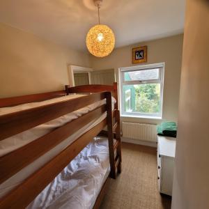 a bedroom with two bunk beds and a window at Pea Cottage in Kessingland
