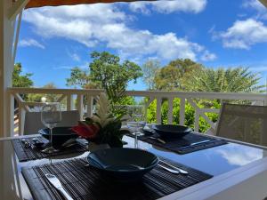 a table on a balcony with a view of the sky at La Belle Epoque (3*) - Maison avec vue sur mer à Bouillante in Bouillante