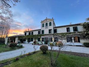 un gran edificio blanco con una puesta de sol en el fondo en B&B Villa Gradenigo en Lancenigo