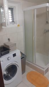 uma máquina de lavar roupa na casa de banho com um chuveiro em Apartment Bepo em Seget Vranjica