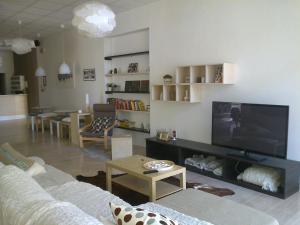 a living room with a couch and a flat screen tv at Hotel Augustus in Milano Marittima +117 photos