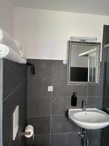 uma casa de banho com um lavatório e um espelho em Seeblick Apartment am Mellensee em Mellensee