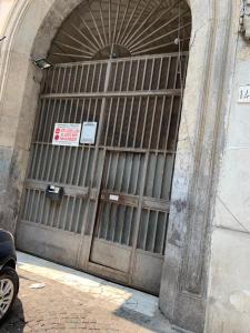 una gran puerta metálica de un edificio con un cartel. en La casina del Conte en Nápoles