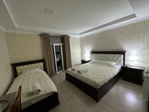 1 dormitorio con 2 camas y espejo en Hotel Latif Samarkand, en Samarkand