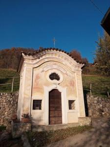un piccolo edificio con una croce sopra di Ai Grilli - Ospitalità e natura a Casto