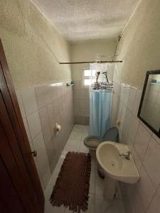 a small bathroom with a toilet and a sink at Recanto do Paraiso in Peruíbe +35 photos