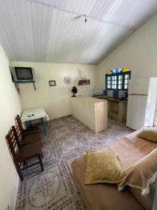 um quarto com uma cama, uma mesa e uma cozinha em Recanto do Paraiso em Peruíbe