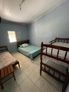 um quarto com 2 beliches e uma janela em Recanto do Paraiso em Peruíbe