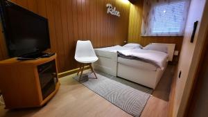 a small bedroom with a bed and a flat screen tv at Bungalow 39 in Tossens in Butjadingen OT Tossens
