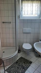 a bathroom with a toilet and a tub and a sink at Bungalow 39 in Tossens in Butjadingen OT Tossens