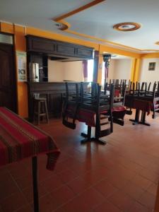une salle à manger avec des chaises et un piano dans l'établissement Uyuni HOSTAL YOKOSO, à Uyuni