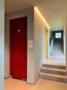 a red door in a hallway with stairs at Albergo Rutzer in Asiago