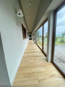 un corridoio con pavimenti in legno e ampie finestre di Albergo Rutzer ad Asiago