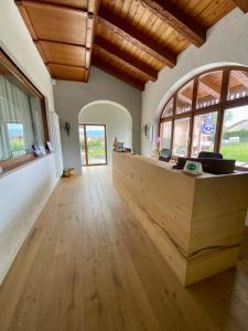 a large room with a wooden counter with windows at Albergo Rutzer in Asiago