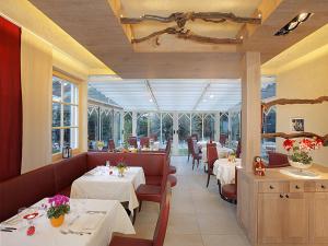 a restaurant with two tables and chairs and a dining room at Pension Weingarten in Lana