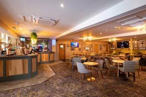 a restaurant with tables and chairs and a bar at Coghurst Hall themed static caravan in Westfield