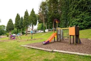 a playground with a slide in a park at Coghurst Hall themed static caravan in Westfield