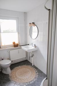a white bathroom with a sink and a toilet at Ferienwohnung Nr 4 Boddenblick Kanu Natur Rügen in Zudar