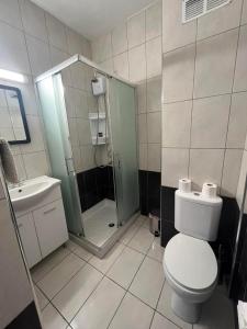 uma casa de banho com um chuveiro, um WC e um lavatório. em Polyxeni Hotel Apartments em Limassol