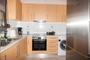 a kitchen with wooden cabinets and a stainless steel refrigerator at kazaplagia in Nea Plagia