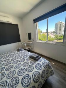 um quarto com uma cama e uma grande janela em Polyxeni Hotel Apartments em Limassol