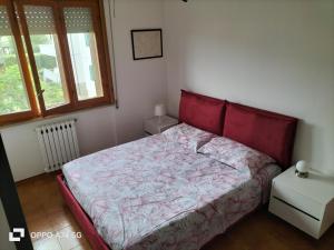 ein Schlafzimmer mit einem roten Bett und einem Fenster in der Unterkunft Bilocale Le Rose in Vada