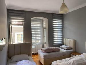 a bedroom with two beds and a mirror and windows at Windrose Hostel Istanbul in Istanbul