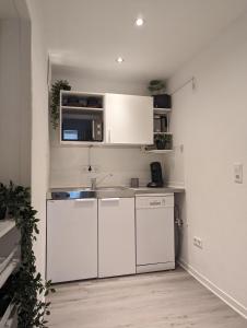 a kitchen with white cabinets and a sink at Ferienwohnung an der historischen Stadtmauer in Cochem +9 photos