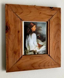 a painting of a woman in a wooden frame at Villa Aurelia in Großkirchheim