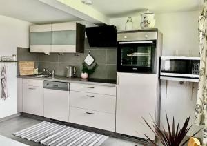 a kitchen with white cabinets and a microwave at Villa Aurelia in Großkirchheim