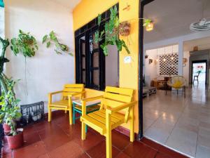 a restaurant with yellow tables and chairs in a room at Bona Vida Apartments in Ríohacha