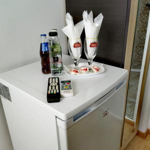 a white refrigerator with two glasses and drinks on it at Casa Georgeta in 2 Mai