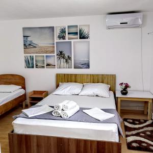 a bed in a room with pictures on the wall at Casa Georgeta 2 Mai-Punct Gastronomic Local-AROME DOBROGENE in 2 Mai