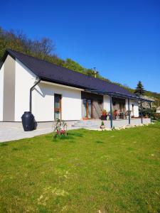 una casa blanca con césped delante en Katáng Vendégház, 