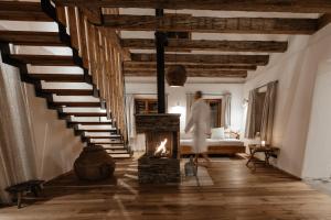 a woman walking through a living room with a fireplace at FRANZL - privates Refugium AmWildbachberg, mit Infinitypool, Weinkeller und Privatsauna in Deutschlandsberg